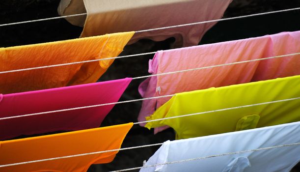 Image shows colorful clothes hanged for drying after alundry