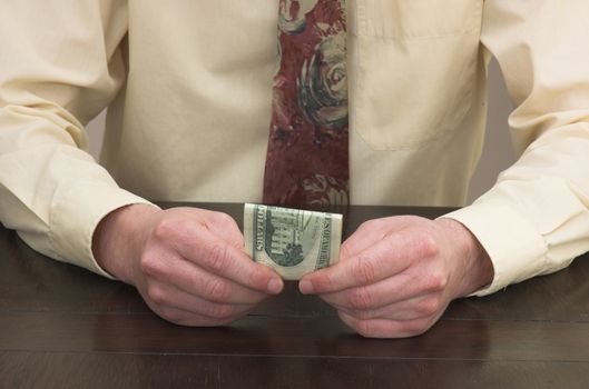 Man working at desk contemplating cash resources.