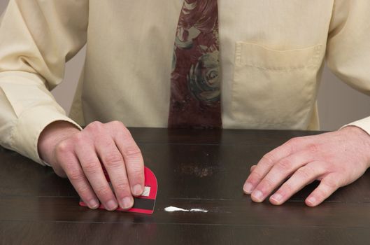 Man preparing a line of cocaine with a credit card.