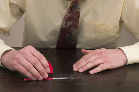 Man preparing a line of cocaine with a credit card.