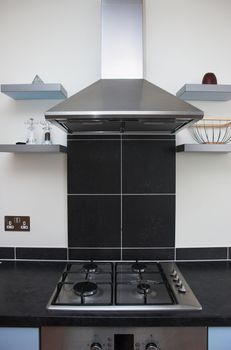 Contemporary kitchen interior detail showing stove top and extractor stainless steel appliances.