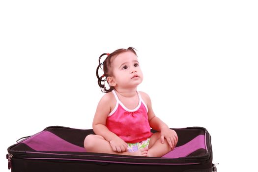 cute little girl sitting on the black suitcase