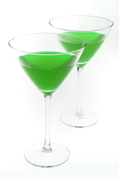 Two cocktail glasses with green liquid inside, isolated on white