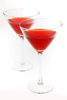 Two cocktail glasses with red liquid inside, isolated on white