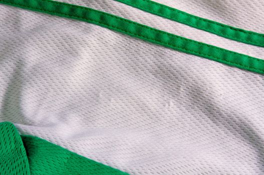 A breathable mesh sports jersey material with green stripes.