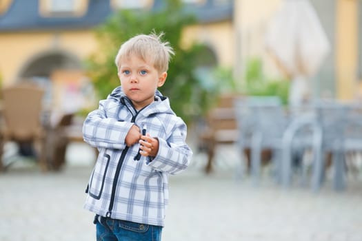 cute little boy outdoors in city street