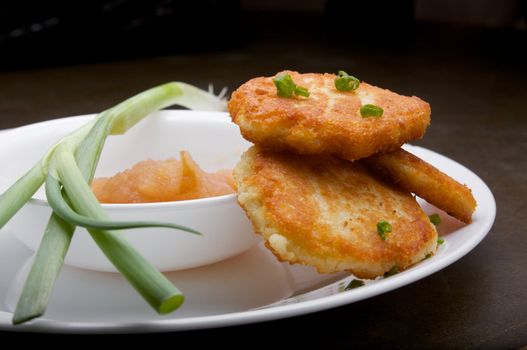 Latkes with Apple Sauce and Green Onion on a white plate