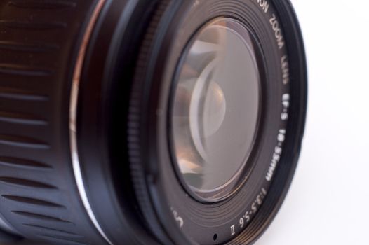 A photographic lens seen from a side angle over white