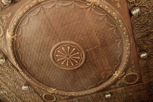 An ornate metal ceiling in a hotel lobby