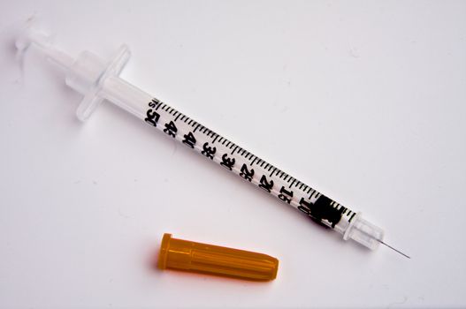 A syringe isolated on a white background, with the cap removed