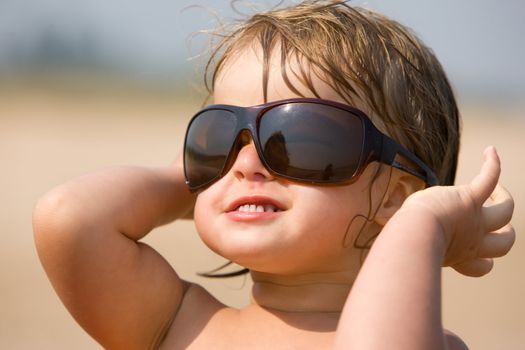 little girl are play with the sun glasses