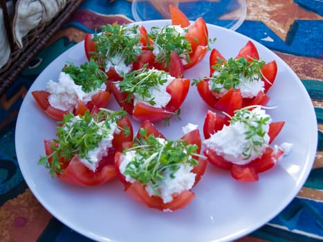 Freshly cut tomatoes served with cheese and green herbs