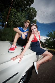 Hipster Couple Sitting on an Old Car