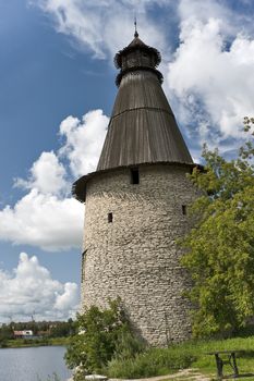Tower with conic wooden roof near river