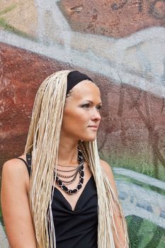 Young woman with braided and graffiti on the wall