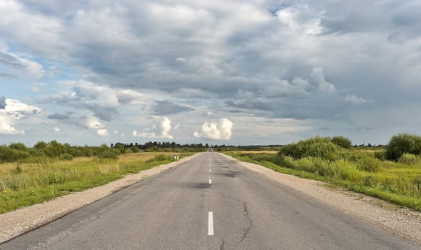 Countryside asphalt road with markings and cloudscape