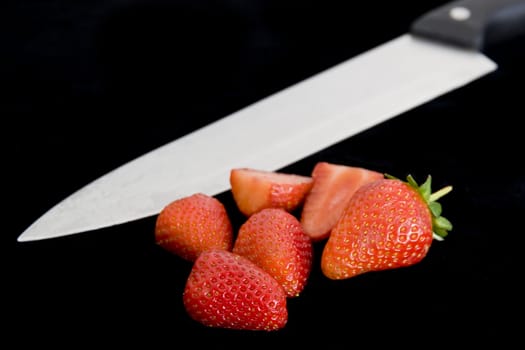 Cut red straberries on a black backround