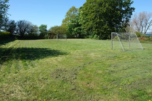 Small country football soccer ground field with goal gates                               