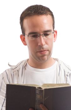 A young man wearing glasses is reading an old bible, isolated against a white background