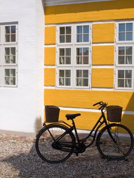 Old vintage retrostyle black bicycle parking by a wall city urban image