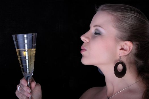 Beautiful blonde with a champagne glass on black background.