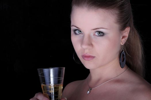 Beautiful blonde with a champagne glass on black background.