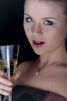 Beautiful blonde with a champagne glass on black background.