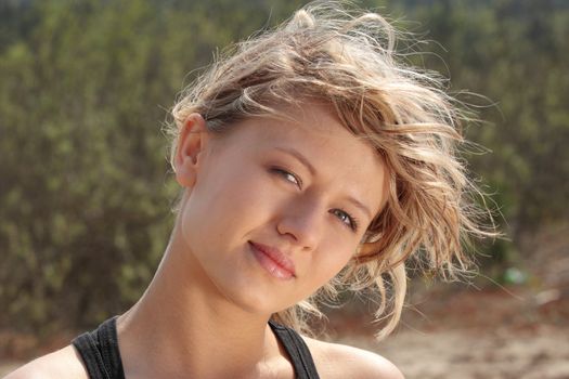 Blond fitness girl in wind portrait (nature background)