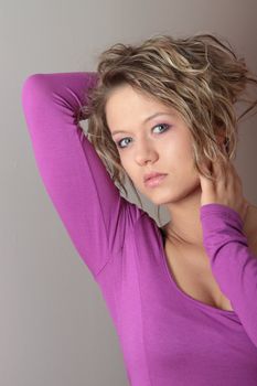 Beautiful blond girl (woman) in a violet dress posing