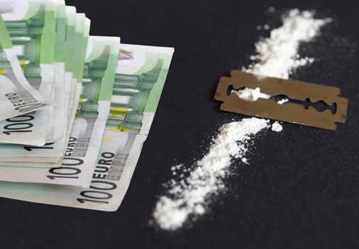 Cocaine, razor blade and money (simulation using wheat flour, no actual drugs used)
