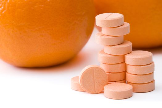 Pills of vitamin C on a background of orange