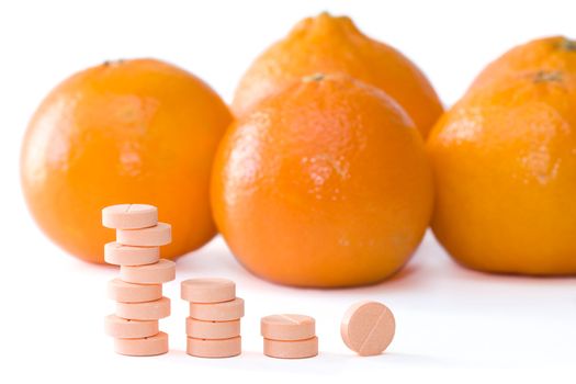 Pills of vitamin C on a background of orange