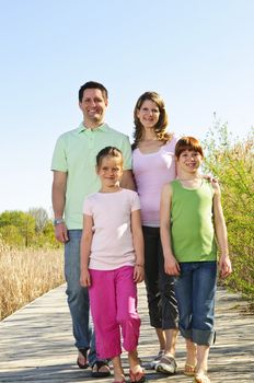 Portrait of happy family of four walking on boardwalk