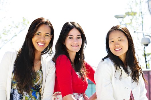 Group of three diverse young girlfriends smiling