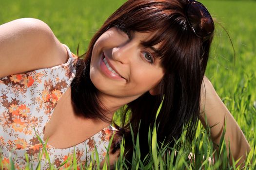 Beautiful and sexy young woman relaxing in the grass