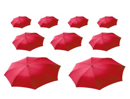 Surrealist perspective of many red umbrellas over white