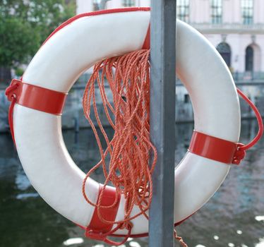 Life buoy on a river over blurred urban background