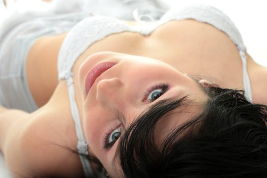 Close-up of beautiful happy woman on the bed in lingerie.