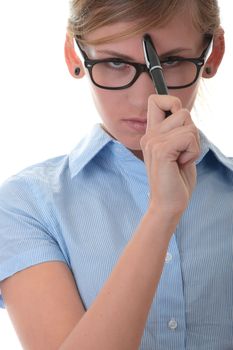 Portrait of a thoughtful young woman in blue shirt holding pen (secretary, student or young businesswoman)