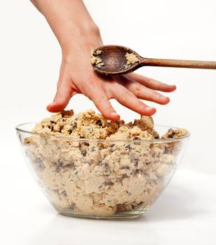 A hand reaching for cookie dough and getting caught