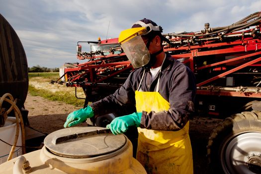 Filling a high clearance sprayer with chemical and water with proper safety equipment