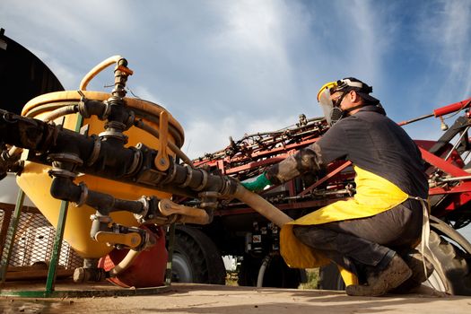 A man filling a high clearance sparying with good chemical safety