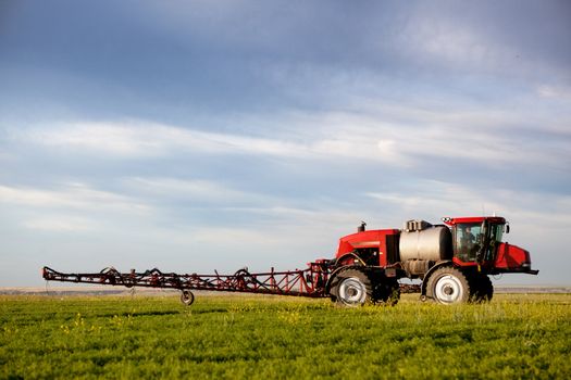 A high clearance sprayer on a field  in a prairie landscape