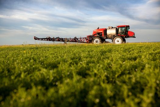 A high clearance sprayer on a field  in a prairie landscape