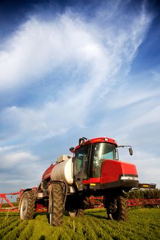 A high clearance sprayer on a field  in a prairie landscape