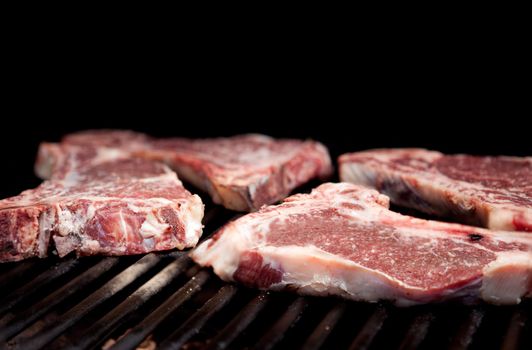 Raw steaks on a grill with shallow depth of field
