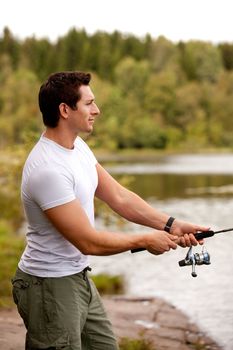 A man fishing on a inerior lake with forest in the background