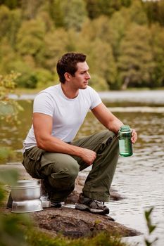 A man getting water on a camping trip in the forest