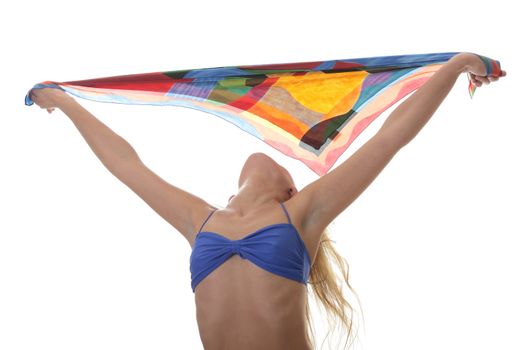 A beautiful young blond woman wearing a blue bikini with colorfull material blowing in the wind isolated on white background