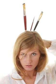 A female blond artist in white uniform with brushes - painting